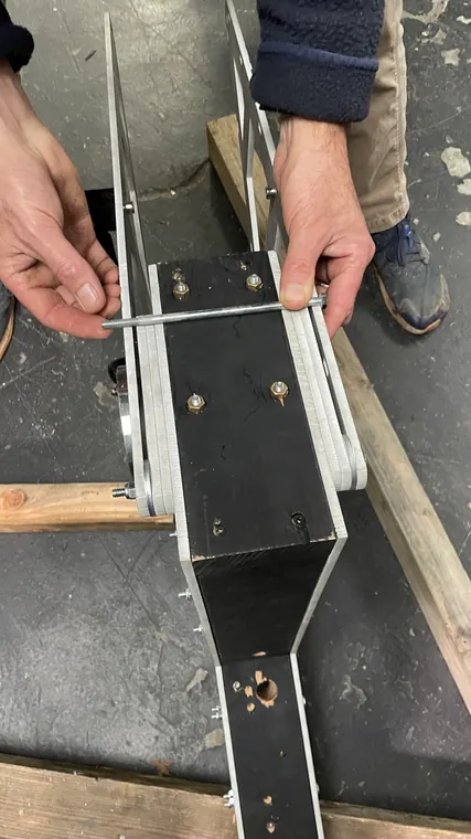 Two hands fitting together the black and aluminum battery box.