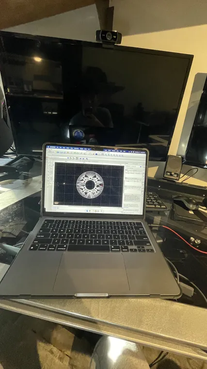 A laptop showing a round hub component drawn in CAD.