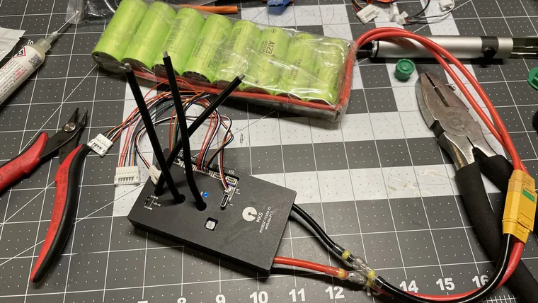 The VESC controller, battery, and wiring laid out on a cutting mat.