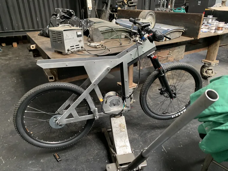 The finished silver bike standing complete in the workshop.