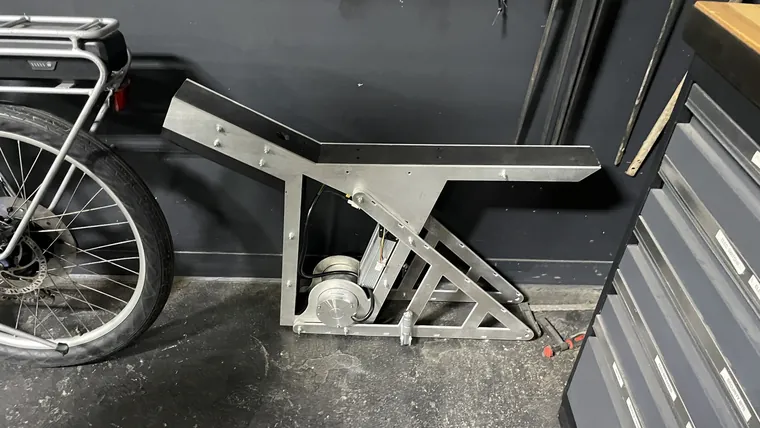 The frame and a wheel loaded beside a truck bed.