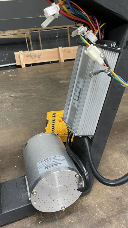 The cylindrical DC motor and its controller wired up on a workbench.