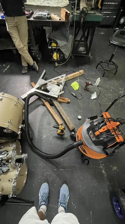 Workshop floor with clamps, tools, and frame parts spread out.
