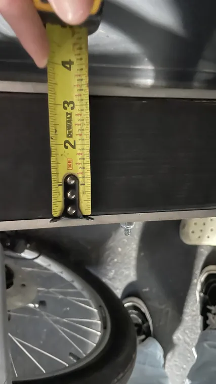 A tape measure held against the wheel to check clearance.