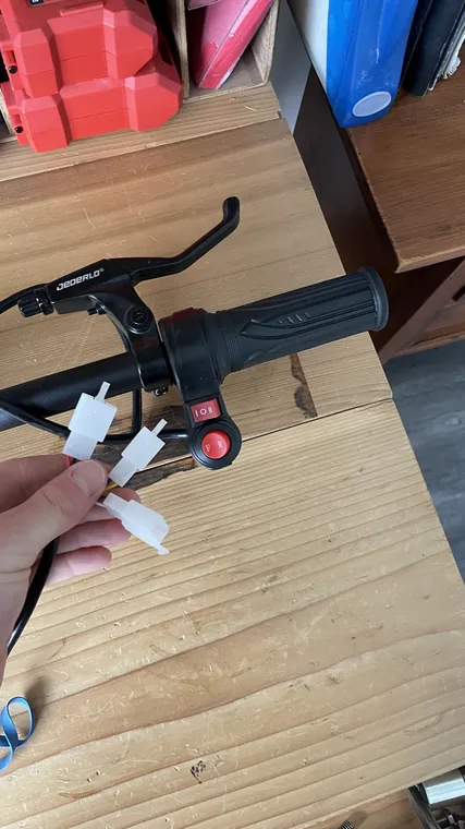 The handlebar with the twist throttle fitted, lying on a wooden table.