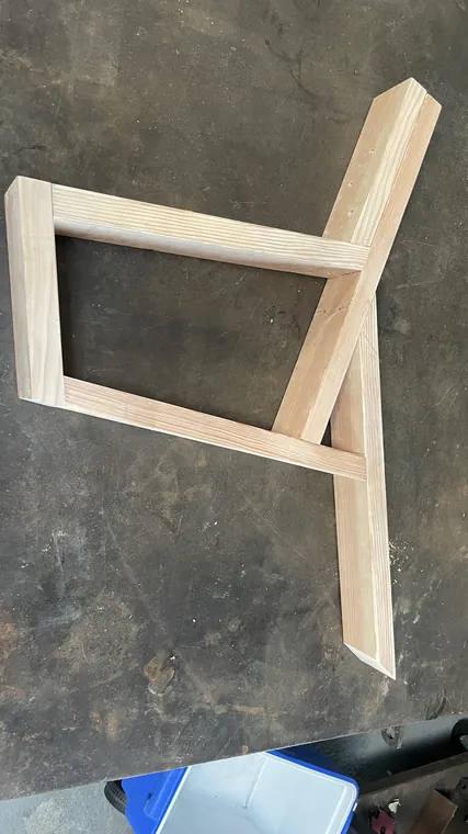 The first wooden frame, assembled from 2x4s, standing on a steel bench.