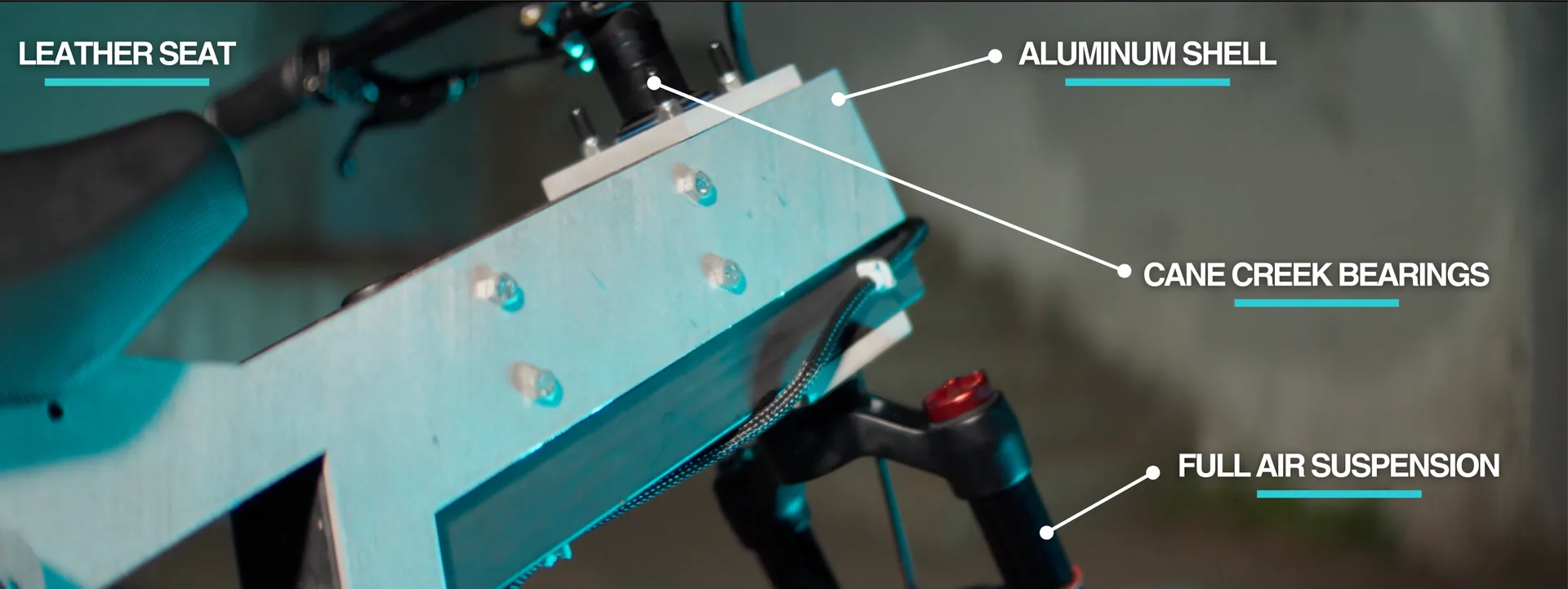 Close-up of the bike's bolted aluminum frame box and seat, with four labelled components.